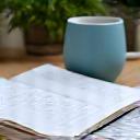 Mano che scrive obiettivi su un blocco note